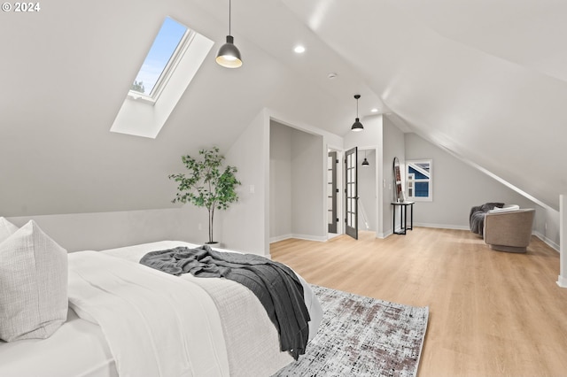 bedroom featuring light wood-type flooring and vaulted ceiling with skylight