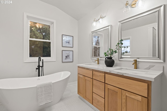 bathroom with a bathtub, vanity, and lofted ceiling