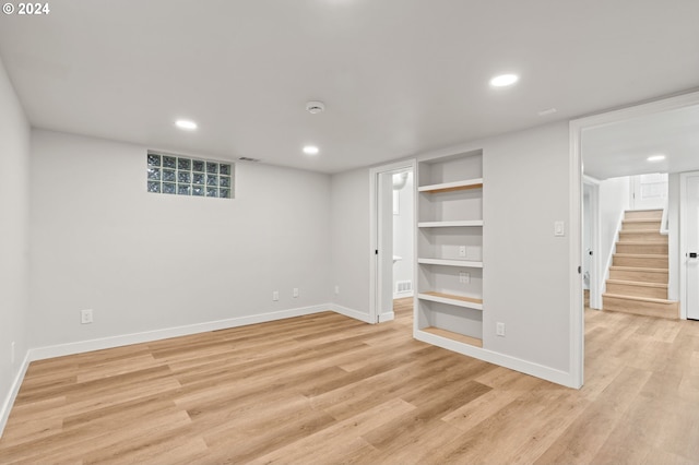 basement with light hardwood / wood-style flooring