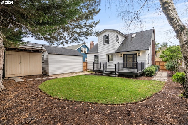 back of house featuring a yard, a deck, and a storage unit