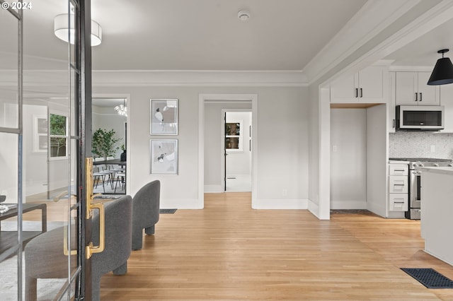 interior space featuring tasteful backsplash, white cabinetry, light hardwood / wood-style floors, and appliances with stainless steel finishes