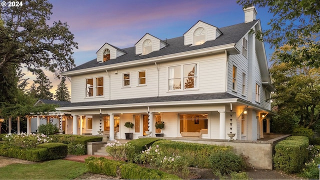 view of front facade featuring a shingled roof, a chimney, and a pergola