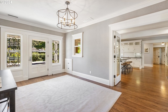 interior space with baseboards, visible vents, dark wood finished floors, ornamental molding, and a notable chandelier