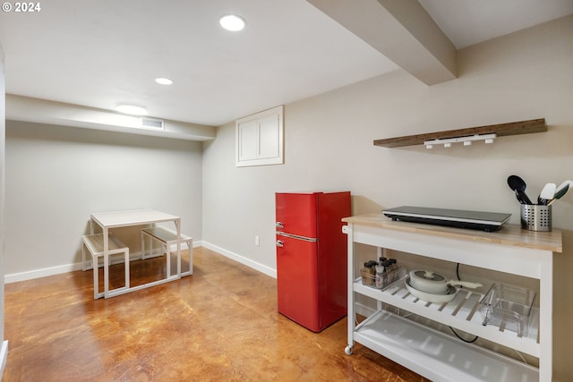 finished below grade area featuring visible vents, freestanding refrigerator, baseboards, and recessed lighting