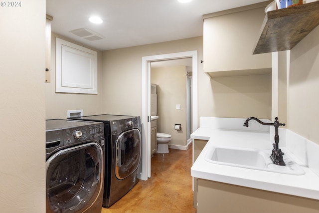 laundry area with laundry area, visible vents, washer and clothes dryer, and a sink