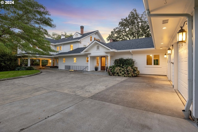 view of front facade with driveway and a chimney