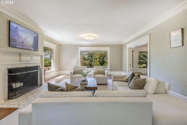 living area featuring a fireplace with flush hearth, crown molding, and baseboards