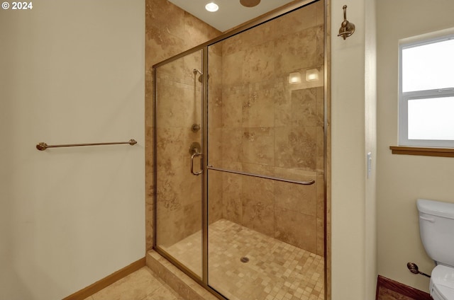 bathroom featuring tile patterned floors, toilet, and walk in shower