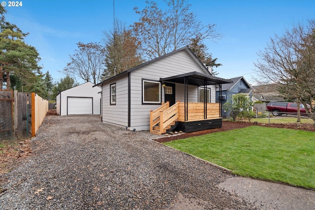 bungalow-style home featuring a garage, an outbuilding, and a front yard