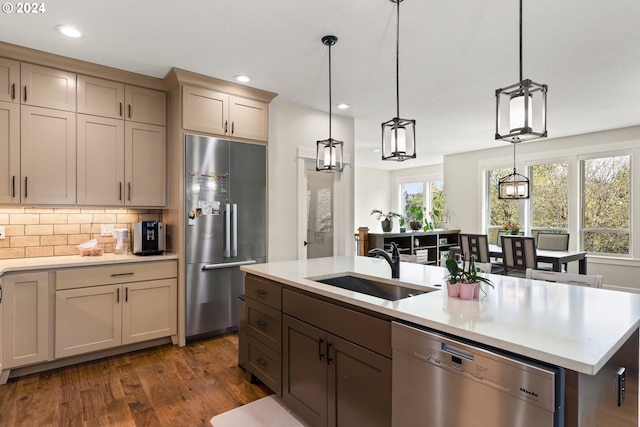 kitchen featuring appliances with stainless steel finishes, decorative backsplash, hardwood / wood-style floors, and cream cabinetry