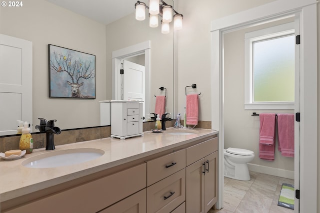 bathroom featuring dual vanity, toilet, and tile patterned floors