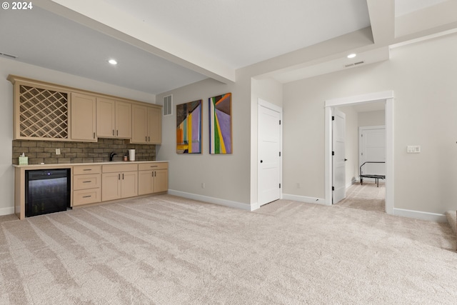 kitchen with sink, light carpet, backsplash, and black dishwasher