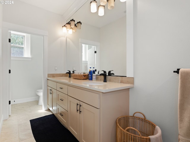 bathroom with tile patterned flooring, toilet, and dual vanity