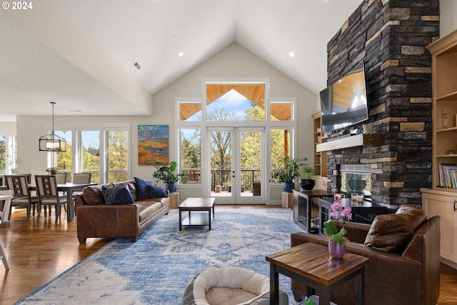 living room featuring a fireplace, high vaulted ceiling, hardwood / wood-style floors, and french doors