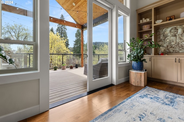 entryway with light wood-type flooring, vaulted ceiling, and a healthy amount of sunlight