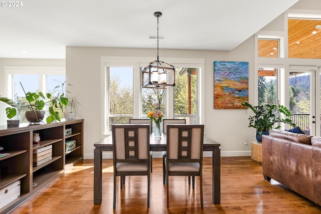 dining area with an inviting chandelier and light hardwood / wood-style flooring