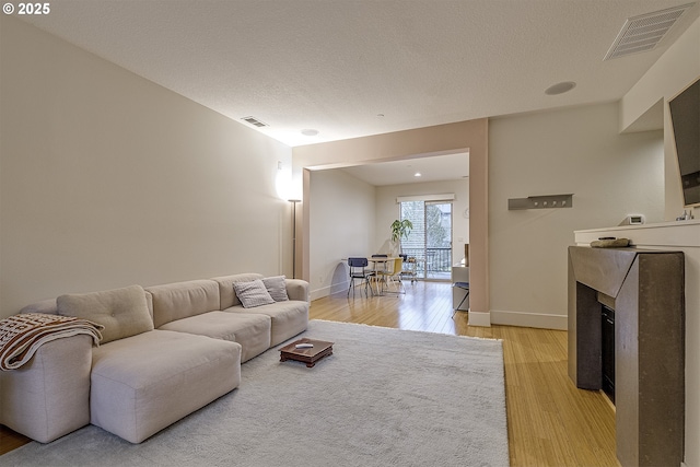 living room featuring a textured ceiling and light hardwood / wood-style flooring