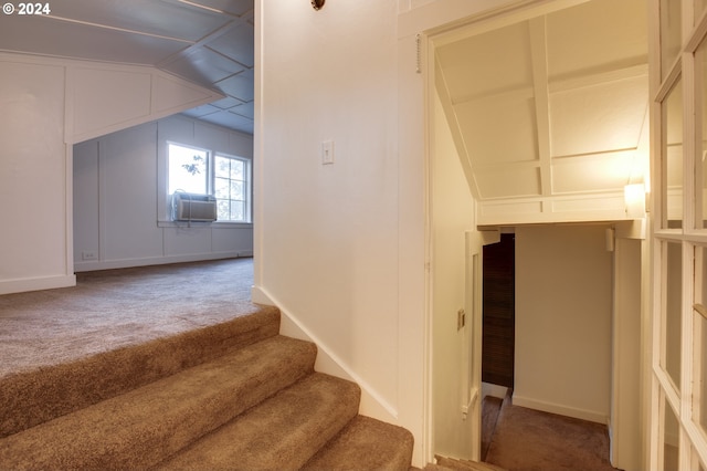 stairs with dark carpet and vaulted ceiling