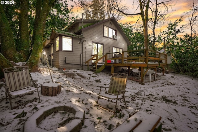 back house at dusk featuring a wooden deck