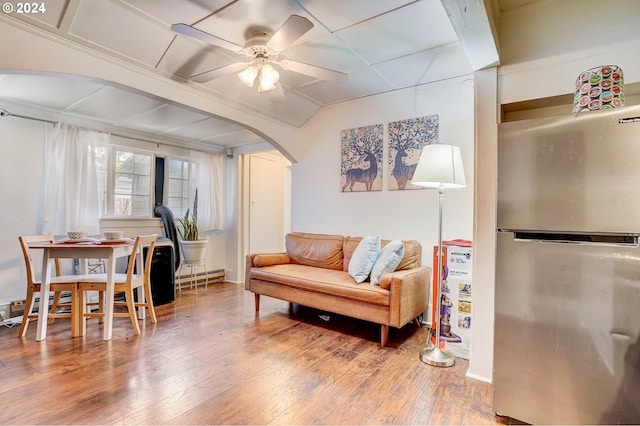 living room featuring ceiling fan, hardwood / wood-style flooring, and a baseboard heating unit