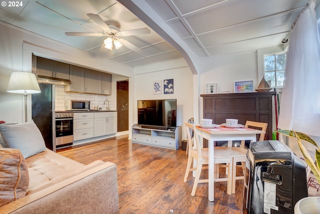 living room featuring ceiling fan, sink, and light hardwood / wood-style flooring