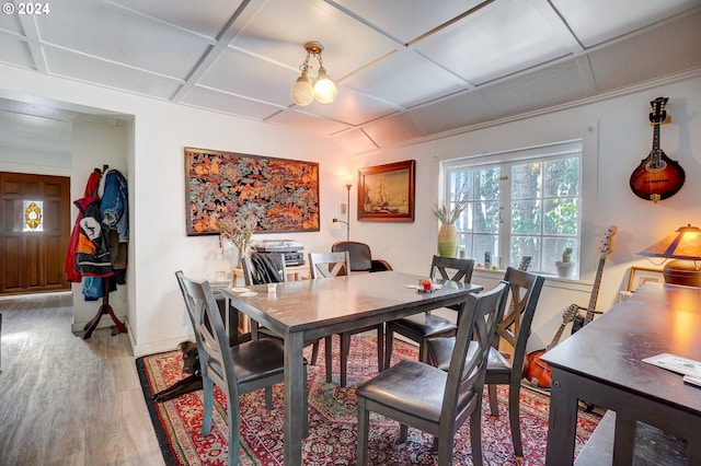 dining space with hardwood / wood-style floors and coffered ceiling