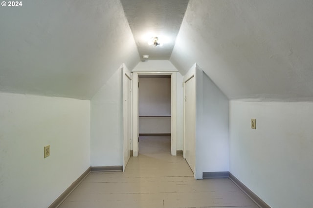 additional living space featuring lofted ceiling and light wood-type flooring