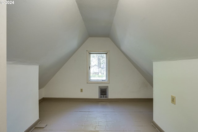 additional living space with heating unit and lofted ceiling