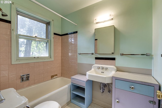 full bathroom with tiled shower / bath combo, toilet, and sink