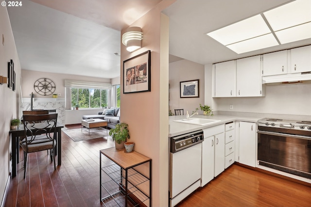 kitchen featuring a skylight, white cabinetry, sink, stove, and white dishwasher