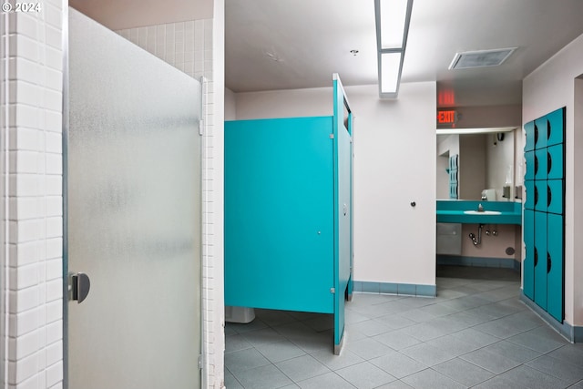 bathroom with tile patterned flooring, sink, and a shower with shower door