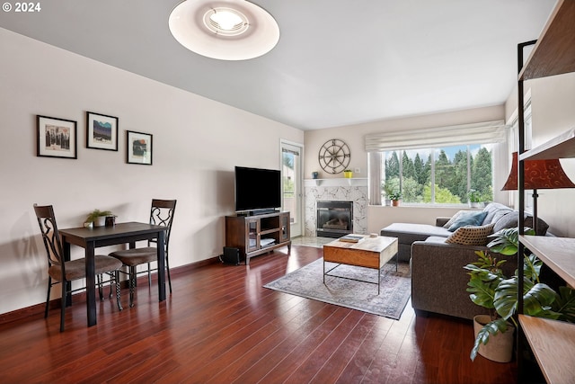 living room featuring a high end fireplace and dark hardwood / wood-style flooring