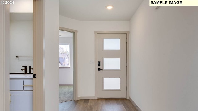 doorway with sink and light hardwood / wood-style flooring