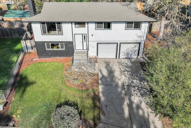 split foyer home with a garage and a front yard