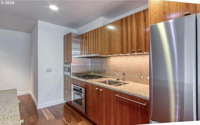 kitchen featuring backsplash, modern cabinets, appliances with stainless steel finishes, and a sink