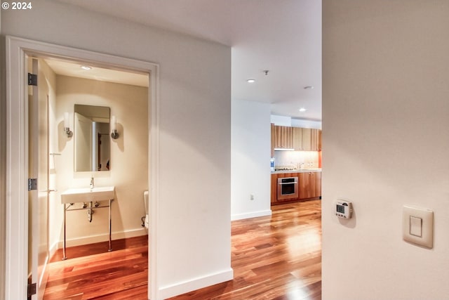 hall with recessed lighting, baseboards, and light wood-style floors