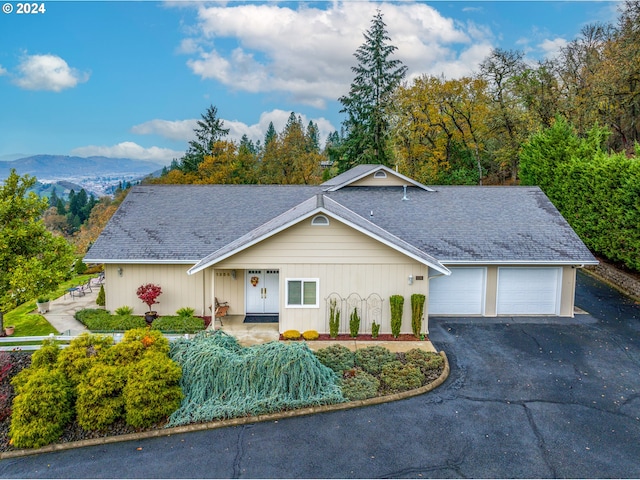 view of front of home with a mountain view, a porch, and a garage