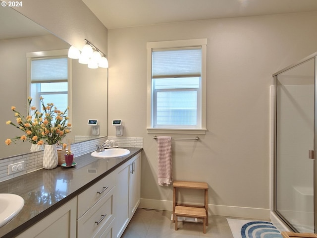 bathroom with walk in shower, tasteful backsplash, vanity, and tile patterned floors