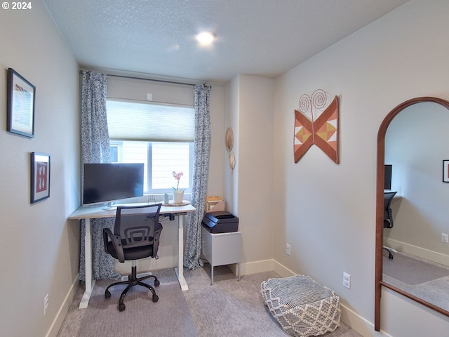 office area with light colored carpet and a textured ceiling