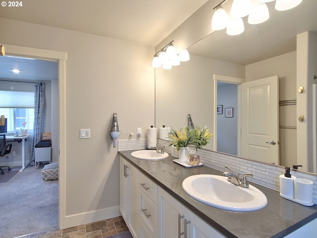 bathroom featuring vanity and backsplash