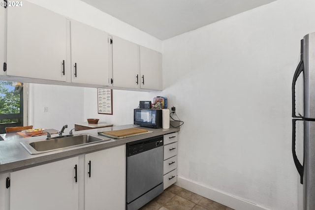 kitchen featuring light tile patterned floors, appliances with stainless steel finishes, sink, and white cabinetry