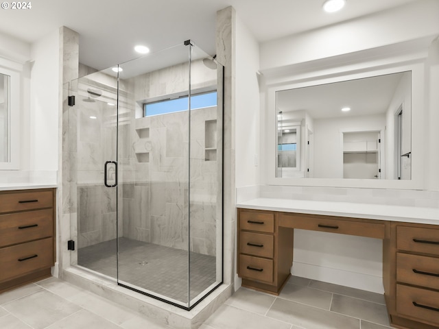 bathroom with tile patterned flooring, vanity, and walk in shower