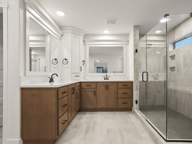 bathroom with tile patterned floors, a shower with door, and vanity