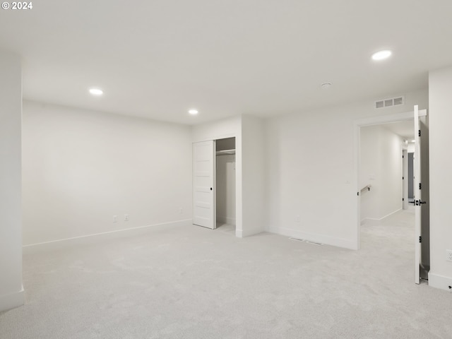 unfurnished bedroom featuring light colored carpet and a closet