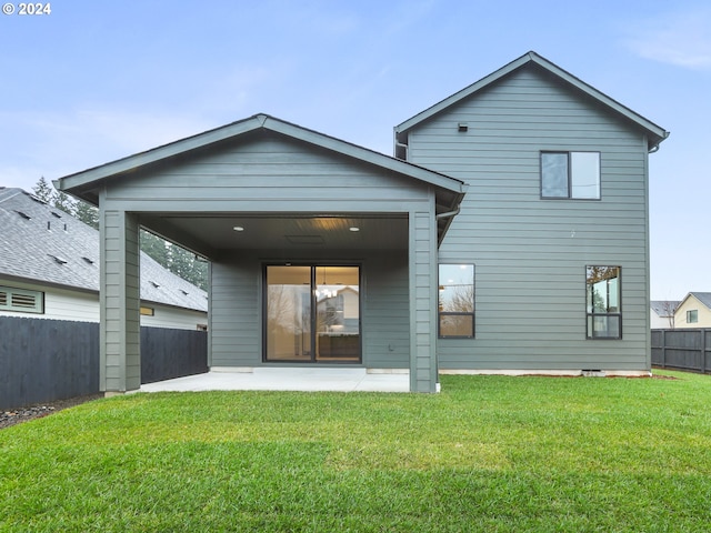 back of house with a yard and a patio