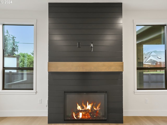 room details with a large fireplace and wood-type flooring