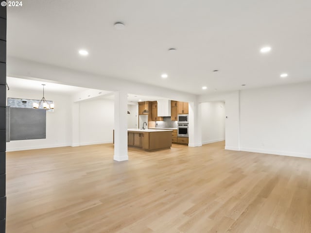 unfurnished living room with sink and light hardwood / wood-style flooring