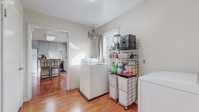 clothes washing area with light wood-type flooring and washing machine and clothes dryer