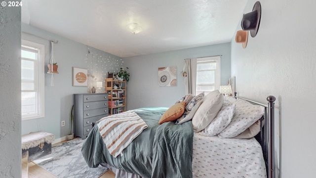 bedroom with light wood-type flooring and multiple windows