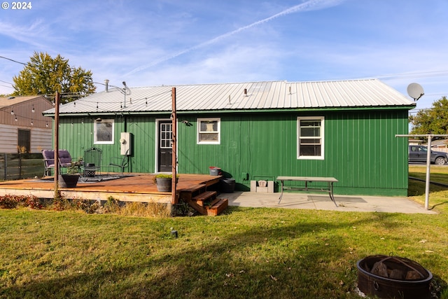 rear view of house featuring a yard, a patio area, and a deck